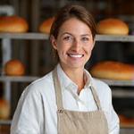 Portrait of Elara Thorpe, Head Baker, smiling warmly in a professional kitchen setting.
