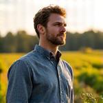 Portrait of Sam Miller, Sourcing Manager, in a field with organic produce.